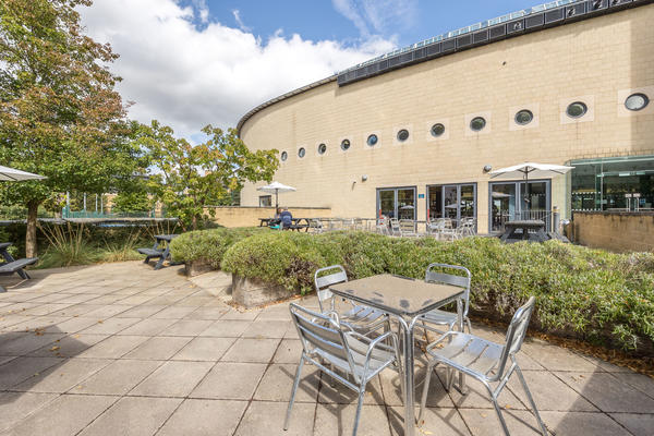 Exterior of University Club showing seating terrace with outdoor tables and chairs
