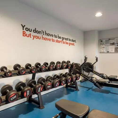 The University Club Gym, showing hand weights and a rowing machine